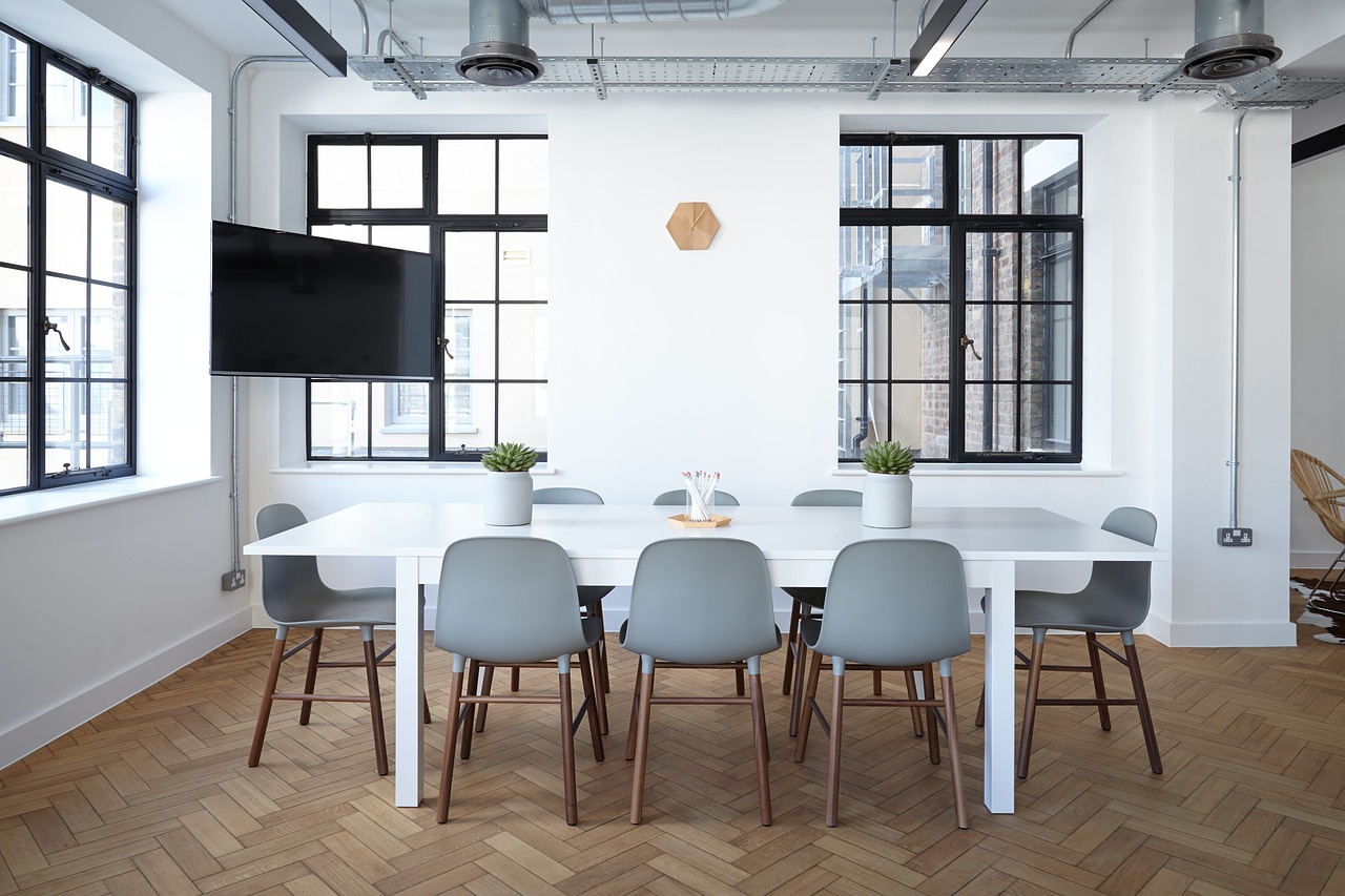 kantoorruimte-met-witte-vergadertafel-en-grijze-stoelen